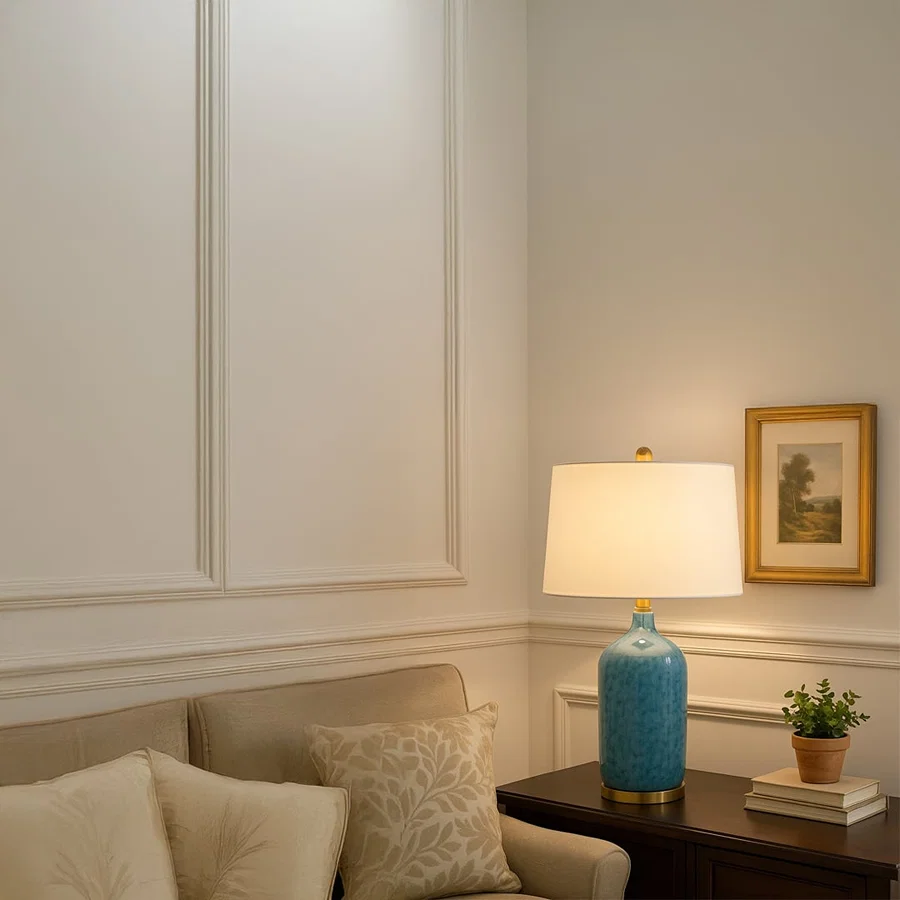 Modern blue ceramic table lamp with gold metal base and white fabric shade adds elegance and a refreshing coastal charm to interiors.