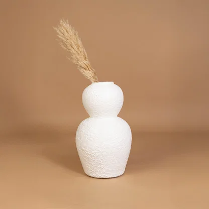 Minimal ceramic vase in white finish with dried grass for table decor or shelf styling modern home placement neutral background.