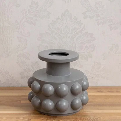 Grey ceramic decorative vase with sculptural bubble design styled on a table for contemporary home decor settings.