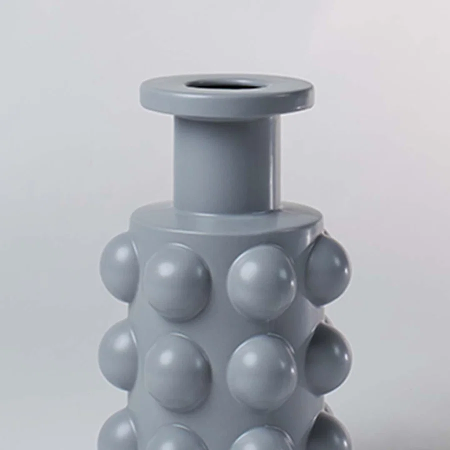 A detailed view of the grey sculptural vase showing its bold raised circular pattern and smooth finish highlighting its unique contemporary form.