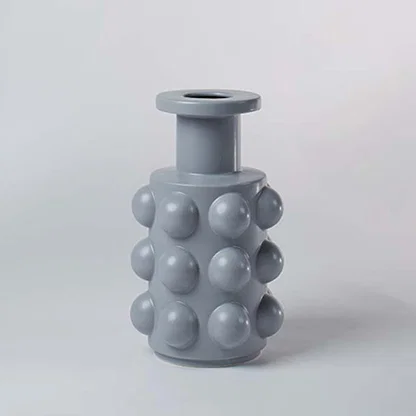Grey ceramic decorative vase with bubble texture and rounded silhouette for contemporary shelf styling and decor.