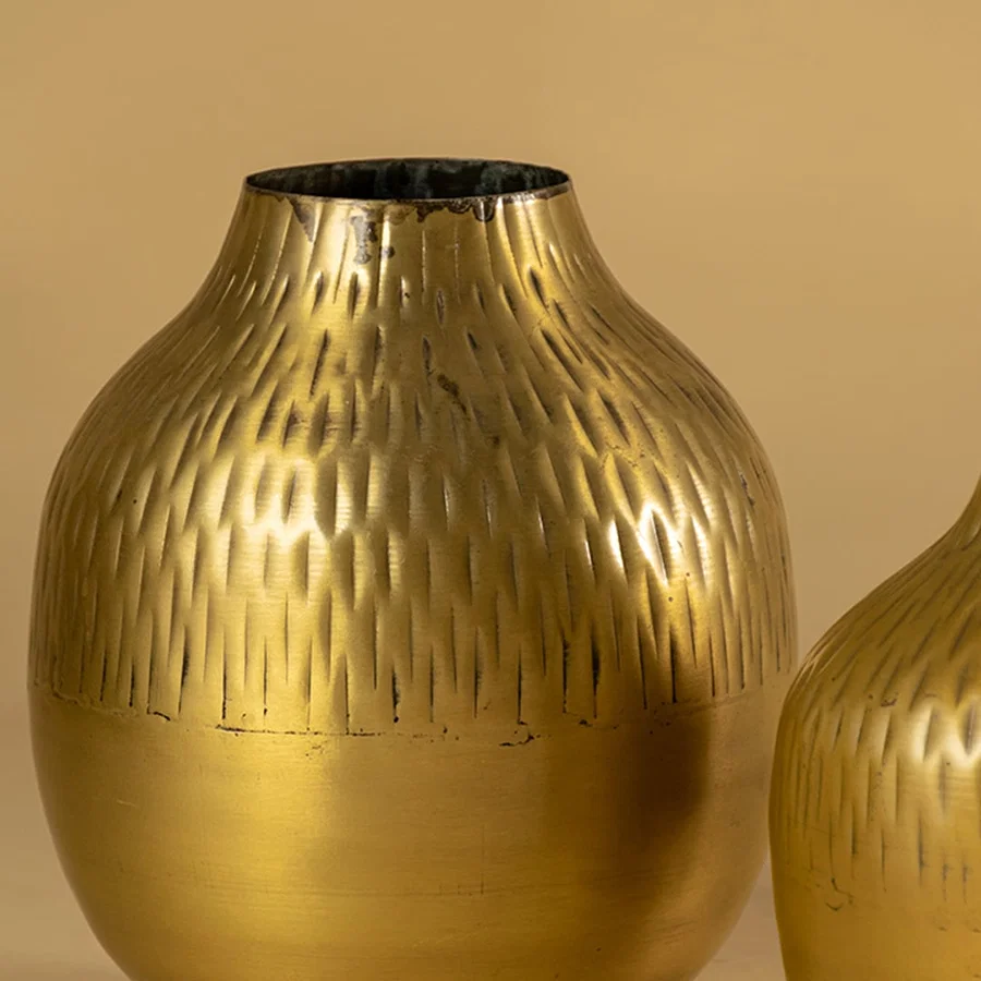Gold hammered metal vase closeup showing textured hammered surface perfect for modern living room shelves and tabletop decor.