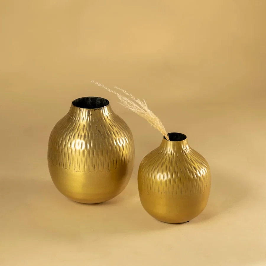 Gold hammered metal vase decor displayed with matching pieces bringing a warm modern touch to shelves console tables and styling.