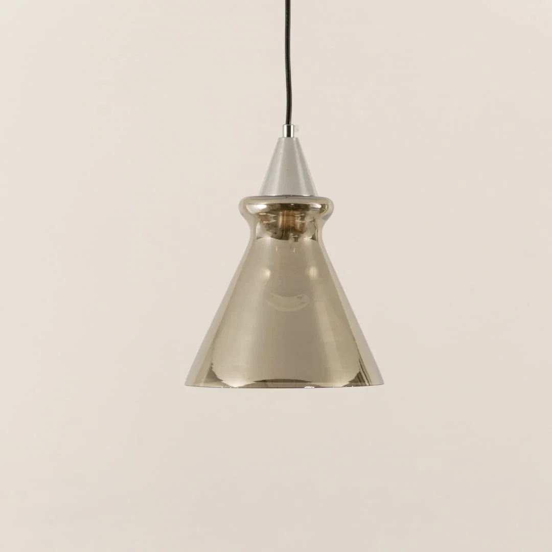 Silver glass pendant light illuminated to display sophisticated modern ceiling lighting with elegant decorative styling.