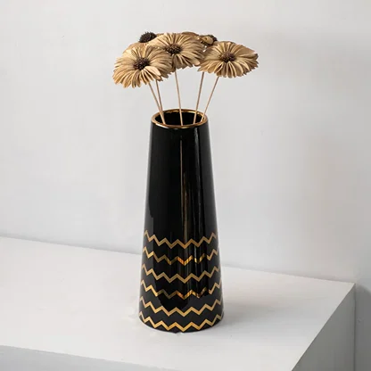 Black ceramic vase with gold zigzag design holding dried flowers modern table decor accent for living room.
