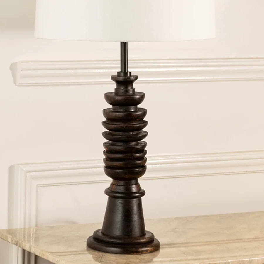 Turned wood lamp base with rich dark finish and bronze accents showcasing classic craftsmanship and decorative appeal.