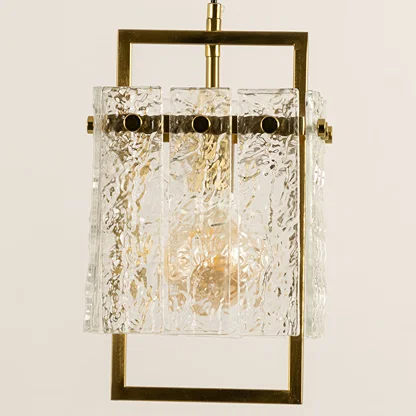 Gold metal wall light with textured glass shade emitting warm glow perfect for modern interior wall decor styling.
