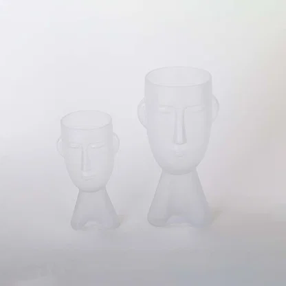 Set of frosted glass vases in abstract face design matte white finish decorative modern accents light on white background for home.