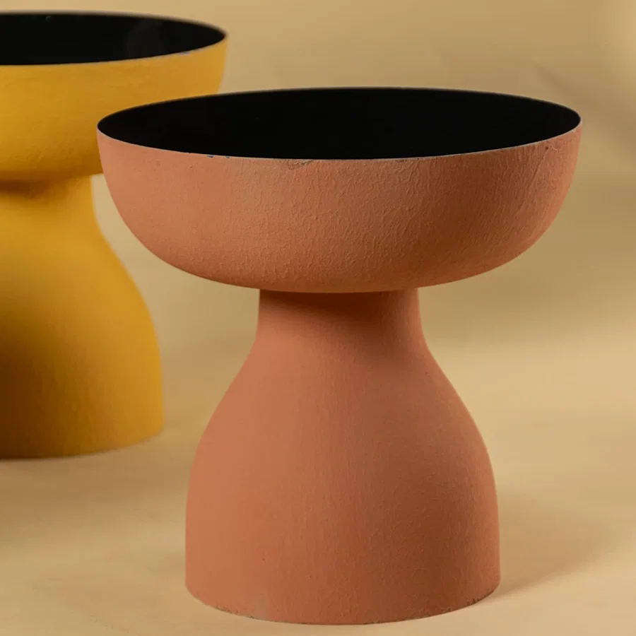 Closeup of grey metal pedestal vase bowl showing textured matte finish and sculptural shape for a modern decor accent.