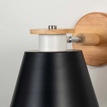 Closeup view of wooden wall sconce with black conical lampshade modern indoor wall light for bedroom living room and hallway table lamping.