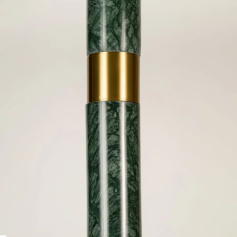 Green marble and gold metal pendant light closeup showcasing premium stone detailing and luxury craftsmanship.