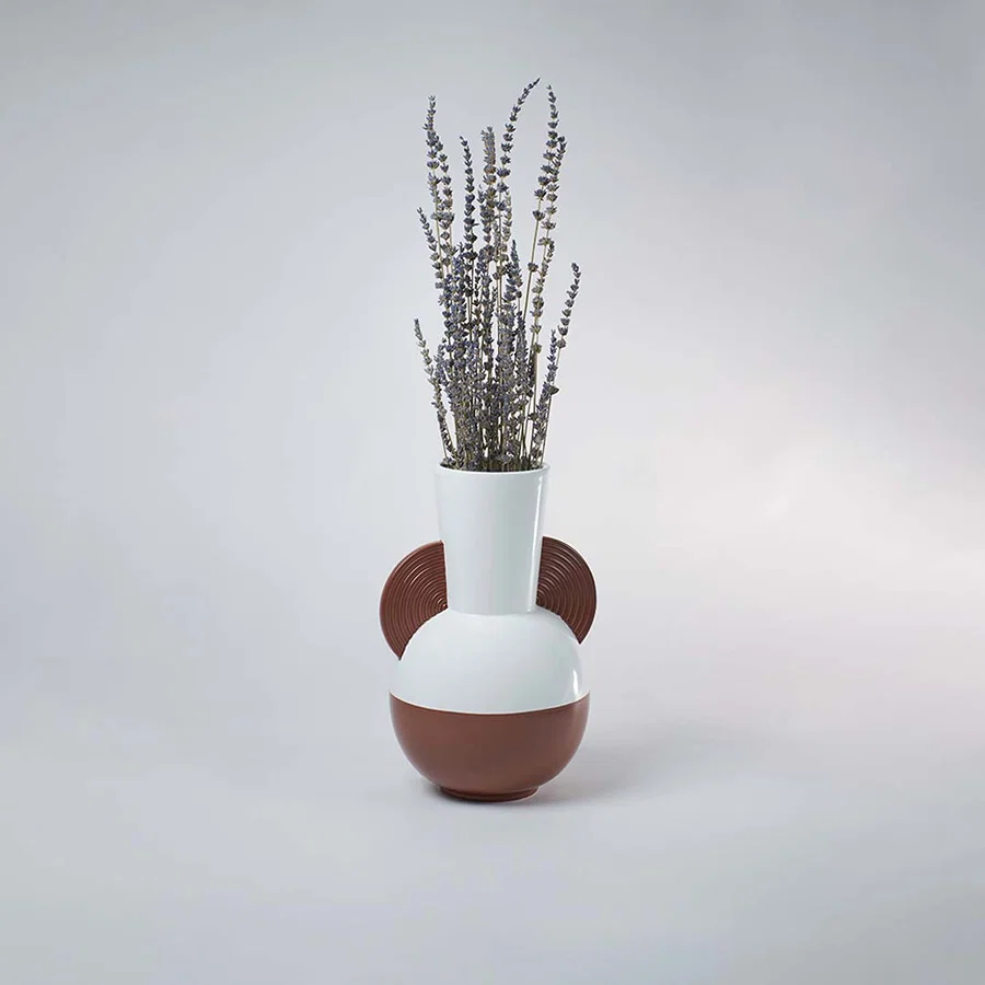 White and brown bulbous ceramic vase with half disc accents styled with dried lavender on a clean white background.