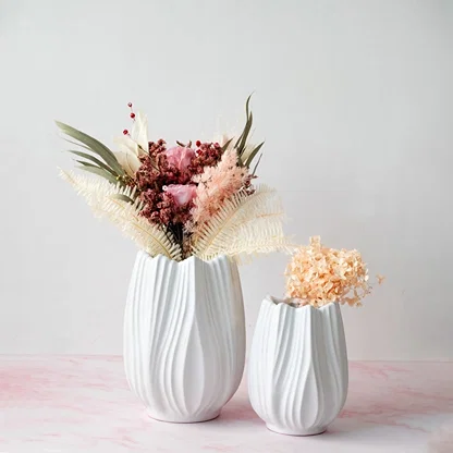 Stylish white ceramic vase with artificial flowers arranged in a modern home setting perfect for living room or dining table decor.
