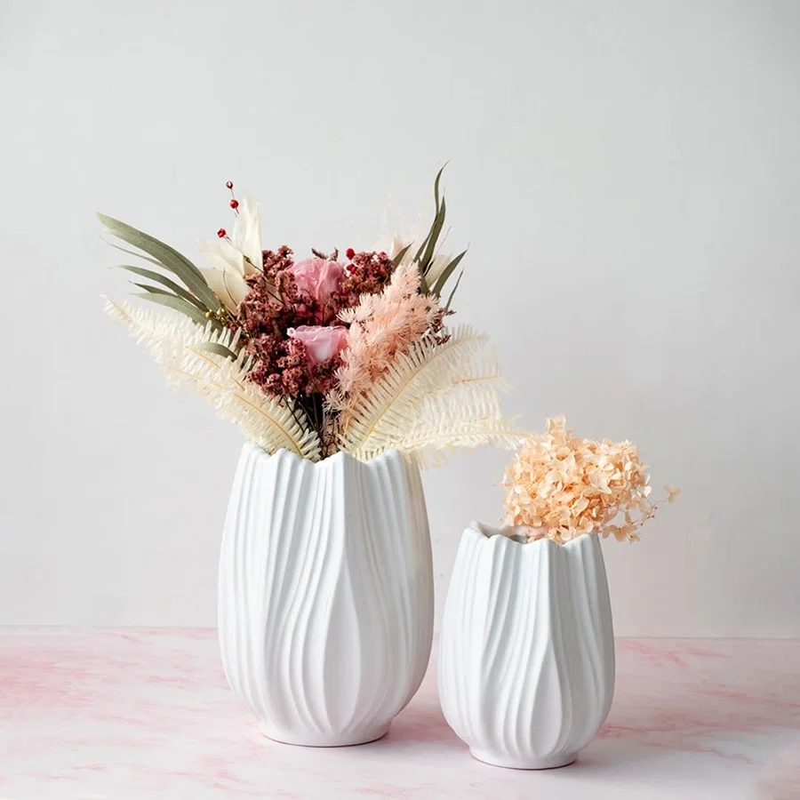 Stylish white ceramic vase with artificial flowers arranged in a modern home setting perfect for living room or dining table decor.