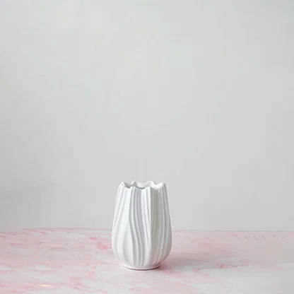 Classic white-ceramic-vase photographed on off-white background displaying smooth texture and modern minimalist style.