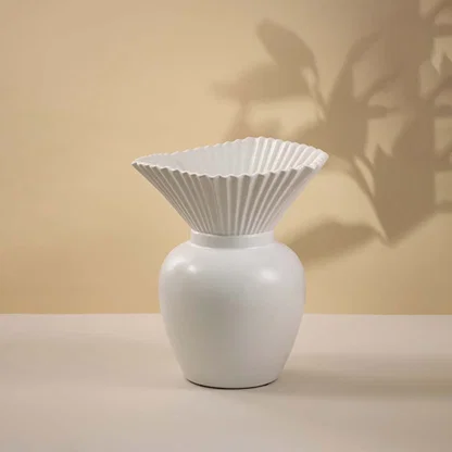 White ceramic decorative vase with fluted flower top and rounded base for modern tabletop styling and home decor.