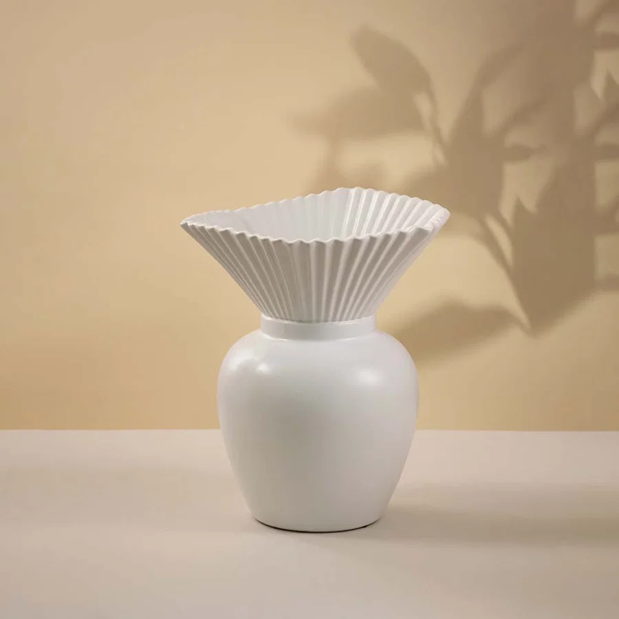 White ceramic decorative vase with fluted flower top and rounded base for modern tabletop styling and home decor.