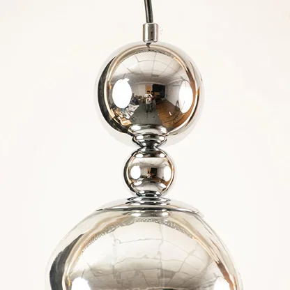 Silver metal pendant light closeup showcasing reflective finish and premium craftsmanship with modern decorative appeal.