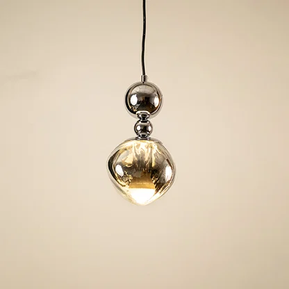 Silver metal pendant light with mirrored finish illuminated to highlight modern decorative ceiling lighting design.