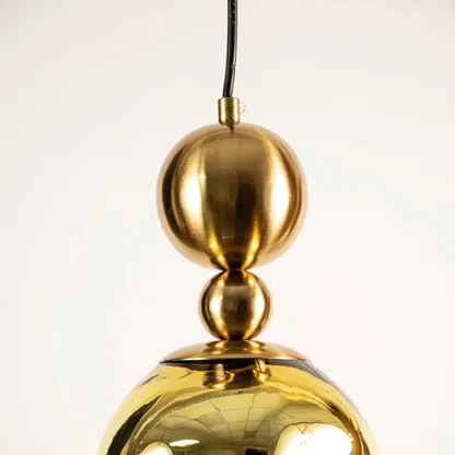 Gold metal pendant light closeup highlighting reflective finish and premium craftsmanship with contemporary design appeal.