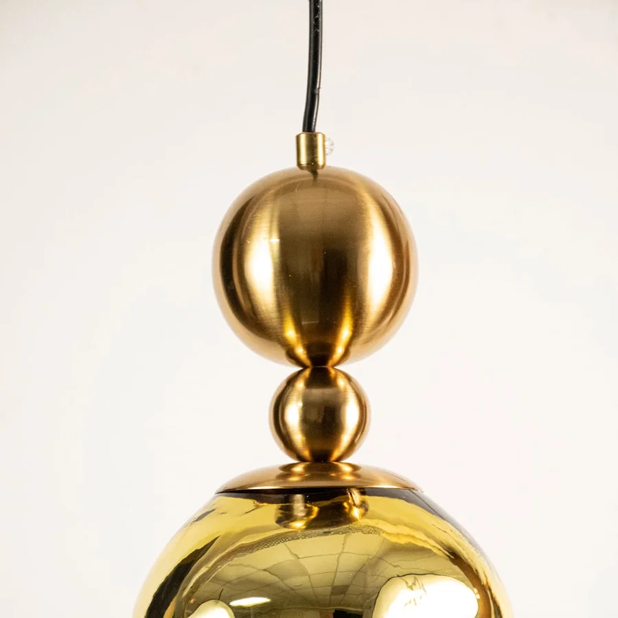 Gold metal pendant light closeup highlighting reflective finish and premium craftsmanship with contemporary design appeal.