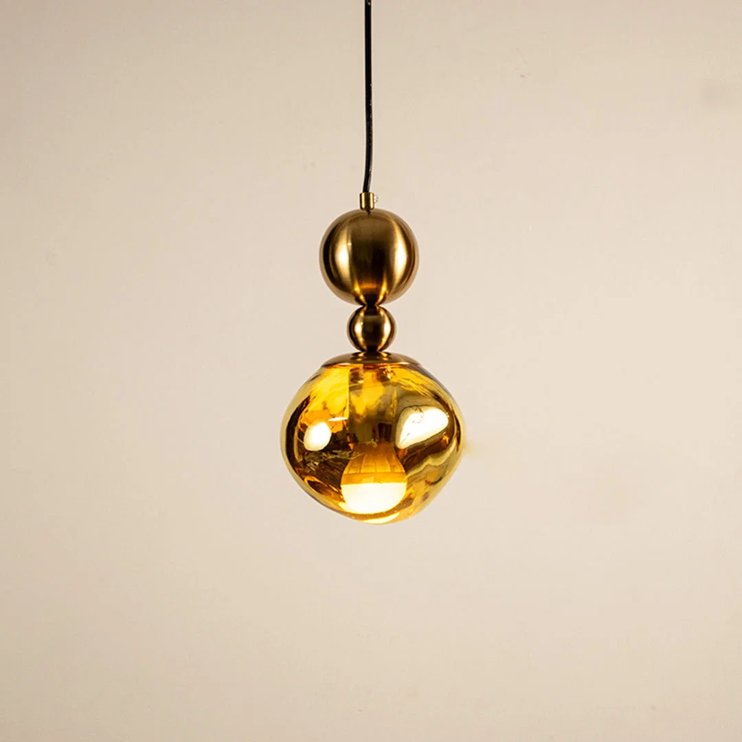 Gold metal pendant light with mirrored finish illuminated to showcase luxury ceiling lighting and modern elegance.