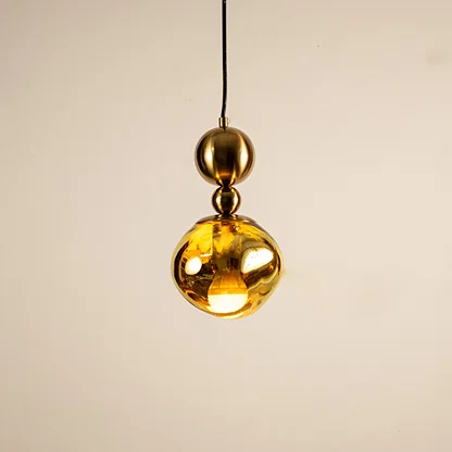 Gold metal pendant light with mirrored finish illuminated to showcase luxury ceiling lighting and modern elegance.