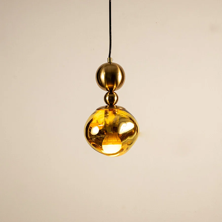 Gold metal pendant light with mirrored finish illuminated to showcase luxury ceiling lighting and modern elegance.