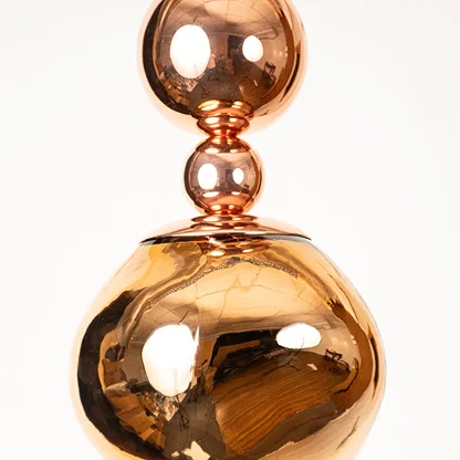 Copper metal pendant light closeup showcasing polished reflective surface and elegant modern lighting craftsmanship.