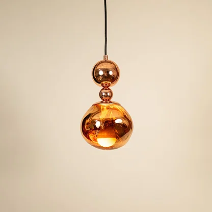 Copper metal pendant light illuminated to display decorative ceiling lighting with warm glow and luxury styling.