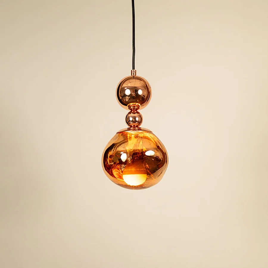 Copper metal pendant light illuminated to display decorative ceiling lighting with warm glow and luxury styling.