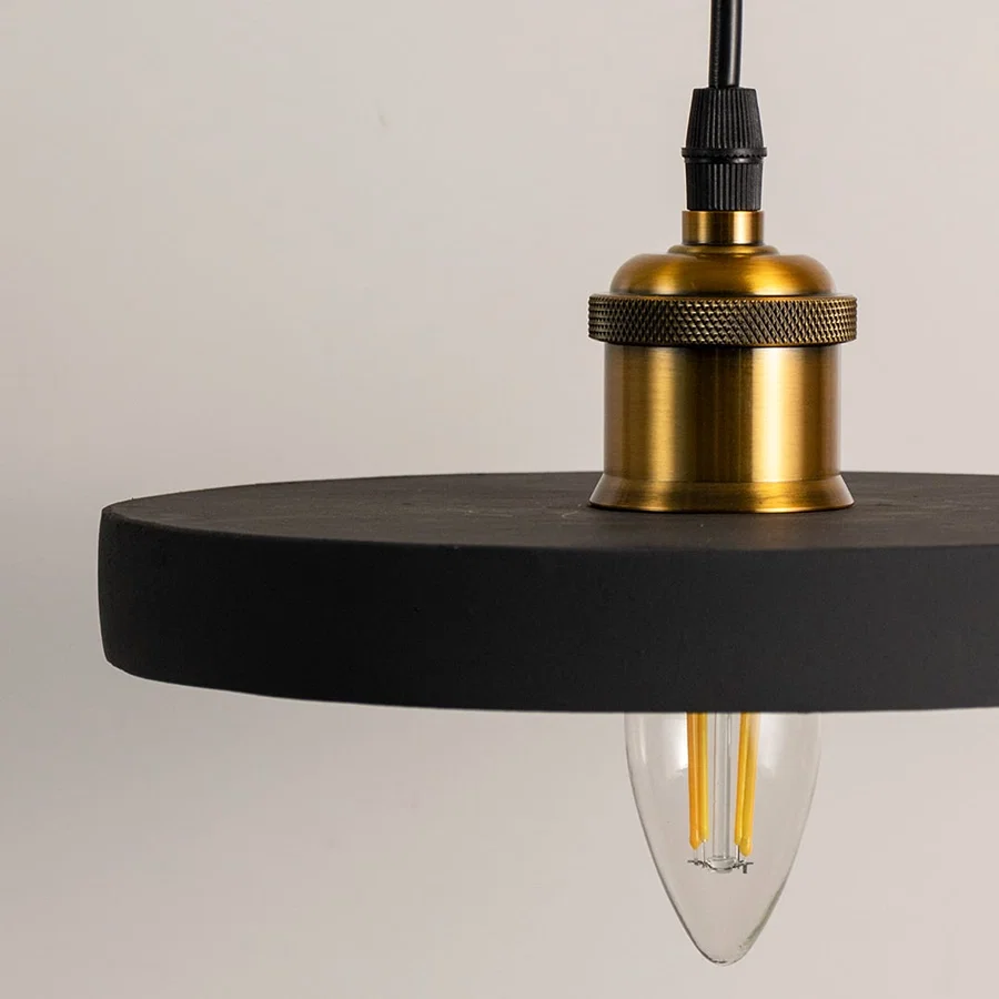Closeup of black metal pendant light with polished gold fittings showcasing premium craftsmanship and style.