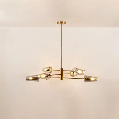 Clear glass chandelier with gold metal frame and illuminated bulbs creating warm contemporary ceiling lighting indoors.