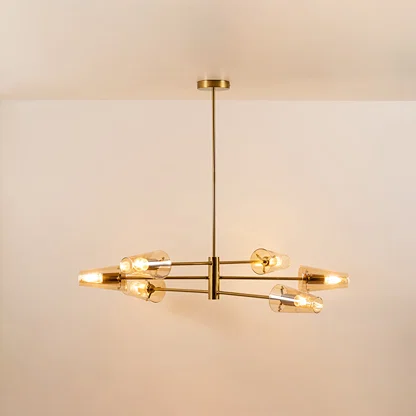Clear glass chandelier with gold metal frame and illuminated bulbs offering elegant contemporary ceiling lighting indoors.