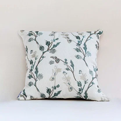 Soft white cotton cushion cover with teal botanical embroidery creating a fresh nature inspired décor accent with a breathable gentle and skin friendly material.