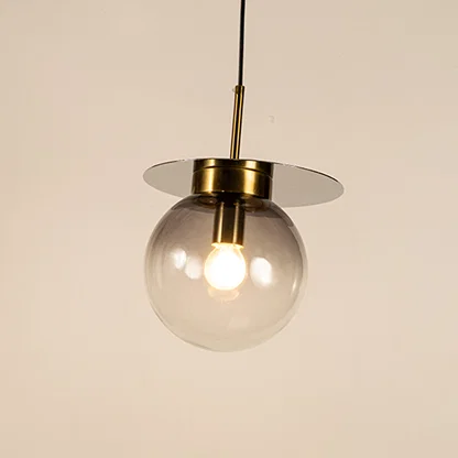 Clear and blue glass globe pendant light with brass accents and decorative disc detail for elegant ceiling lighting decor.