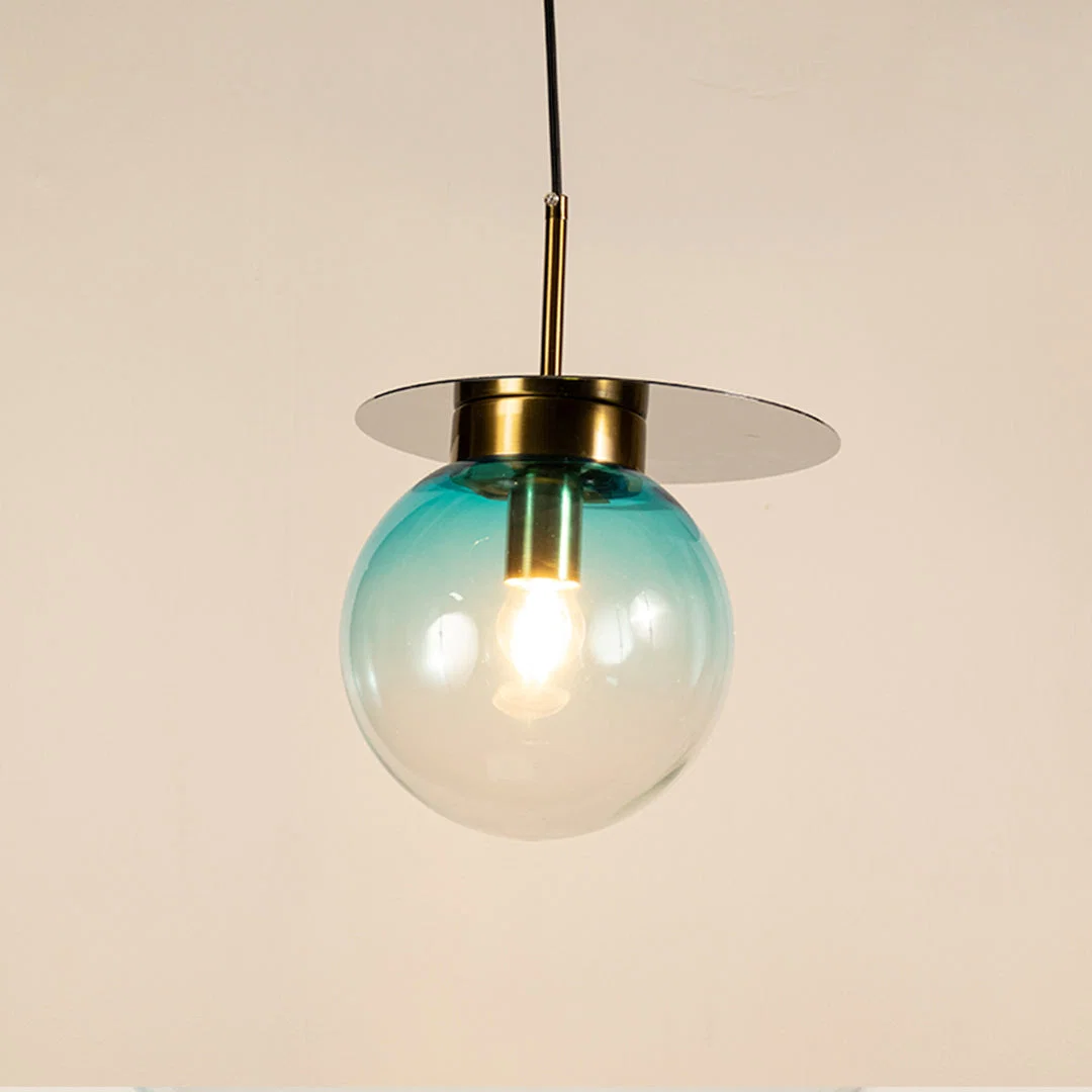 Blue glass globe pendant light with brass metal accents and decorative disc detail for elegant ceiling lighting decor.
