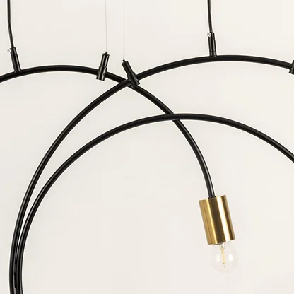 A closeup view of the chandelier showing the smooth black metal arcs and gold bulb holders highlighting premium craftsmanship and modern design details.