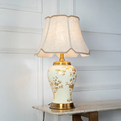 White floral ceramic table lamp with fabric shade placed on a side table adding timeless traditional decor lighting.
