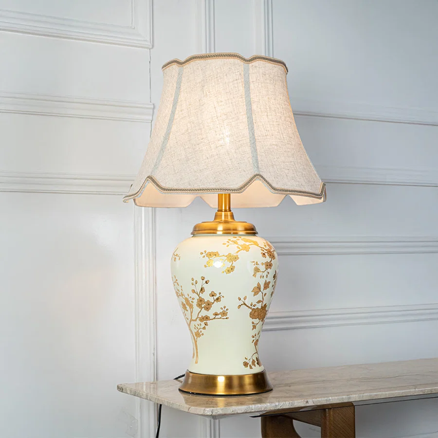 White floral ceramic table lamp with fabric shade placed on a side table adding timeless traditional decor lighting.