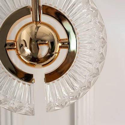 Closeup of gold crystal pendant light with circular frame showcasing sparkling elegance and fine craftsmanship.