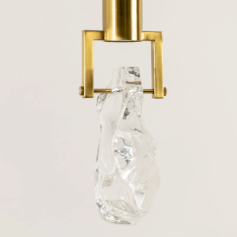 Gold metal pendant light closeup featuring crystal accent detailing and premium luxury lighting craftsmanship quality.