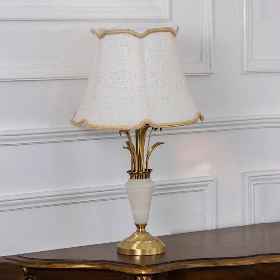 Gold and white marble base table lamp with cream fabric shade turned off against white background home decor table lamp.
