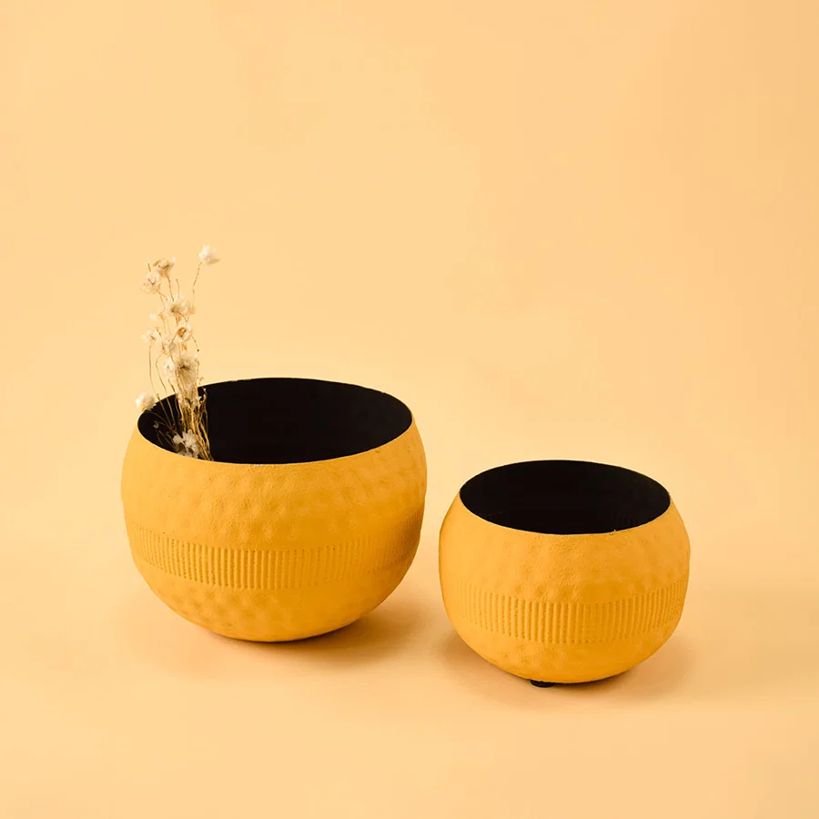 Pair of vibrant textured yellow metal bowls for artistic modern home decor and creative tabletop centerpiece styling.