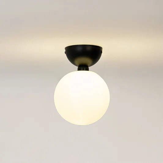 Modern black metal ceiling light with frosted white glass globe for contemporary bedroom and elegant decor styling spaces.