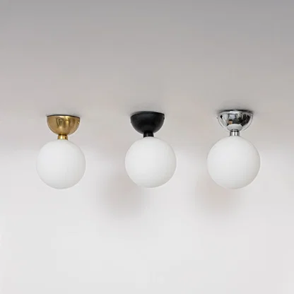 Collection of ceiling lights in chrome gold and black finish with frosted glass globes shown switched off on background.