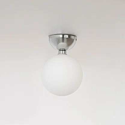 Ceiling light with polished chrome base and frosted glass globe shade shown off on plain white background.