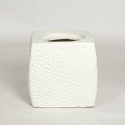 White decorative textured ceramic planter on white background modern home decor accent piece for table floor console styling.
