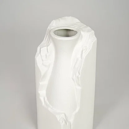 White ceramic flower vase closeup with textured finish modern decorative vase for shelf console table decor styling.