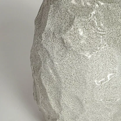 White decorative textured ceramic vase on white background modern home decor accent piece for table shelf console styling.